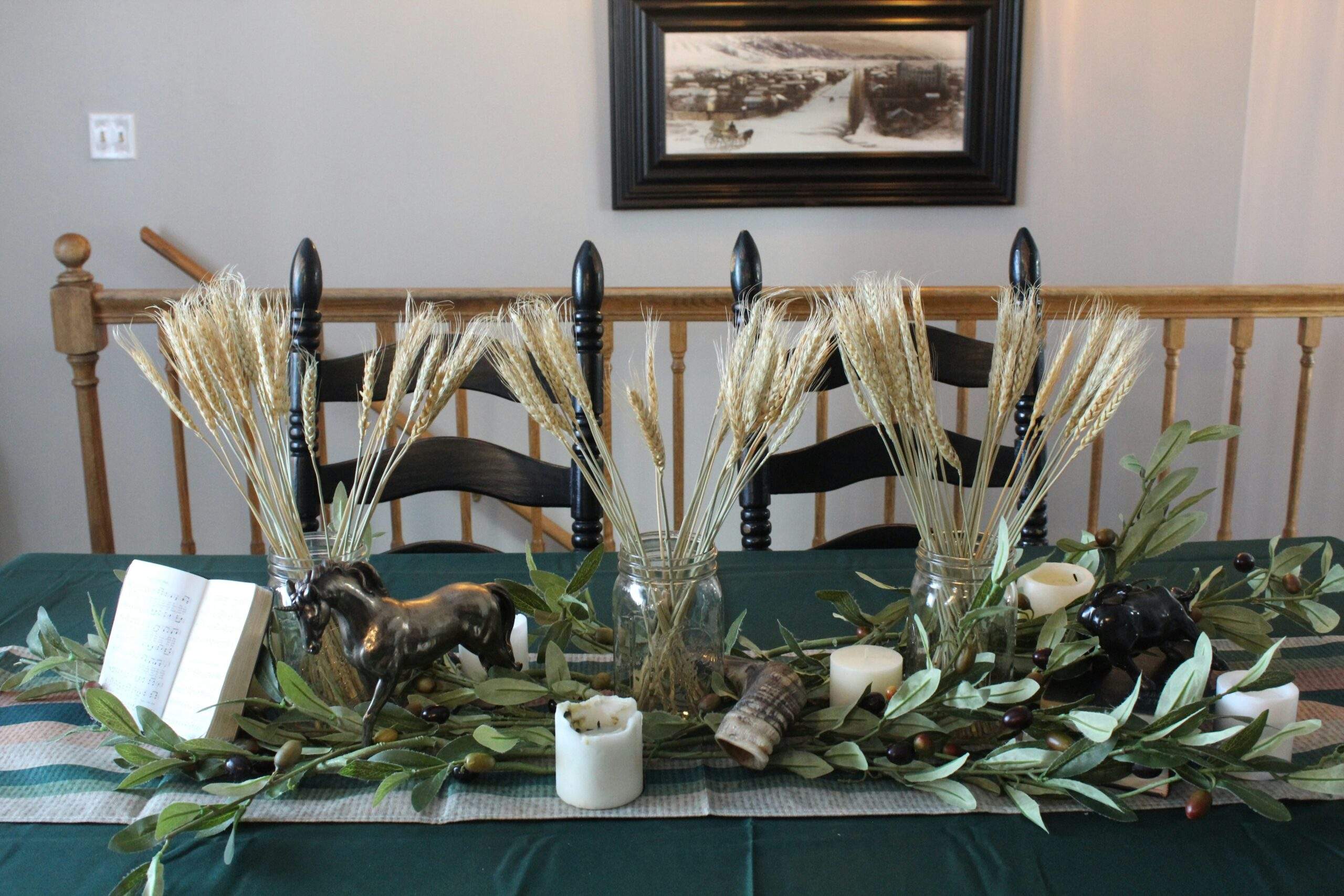 An arrangement of Peace Lilies, Spider Plants, and Aloe Vera on a wooden table