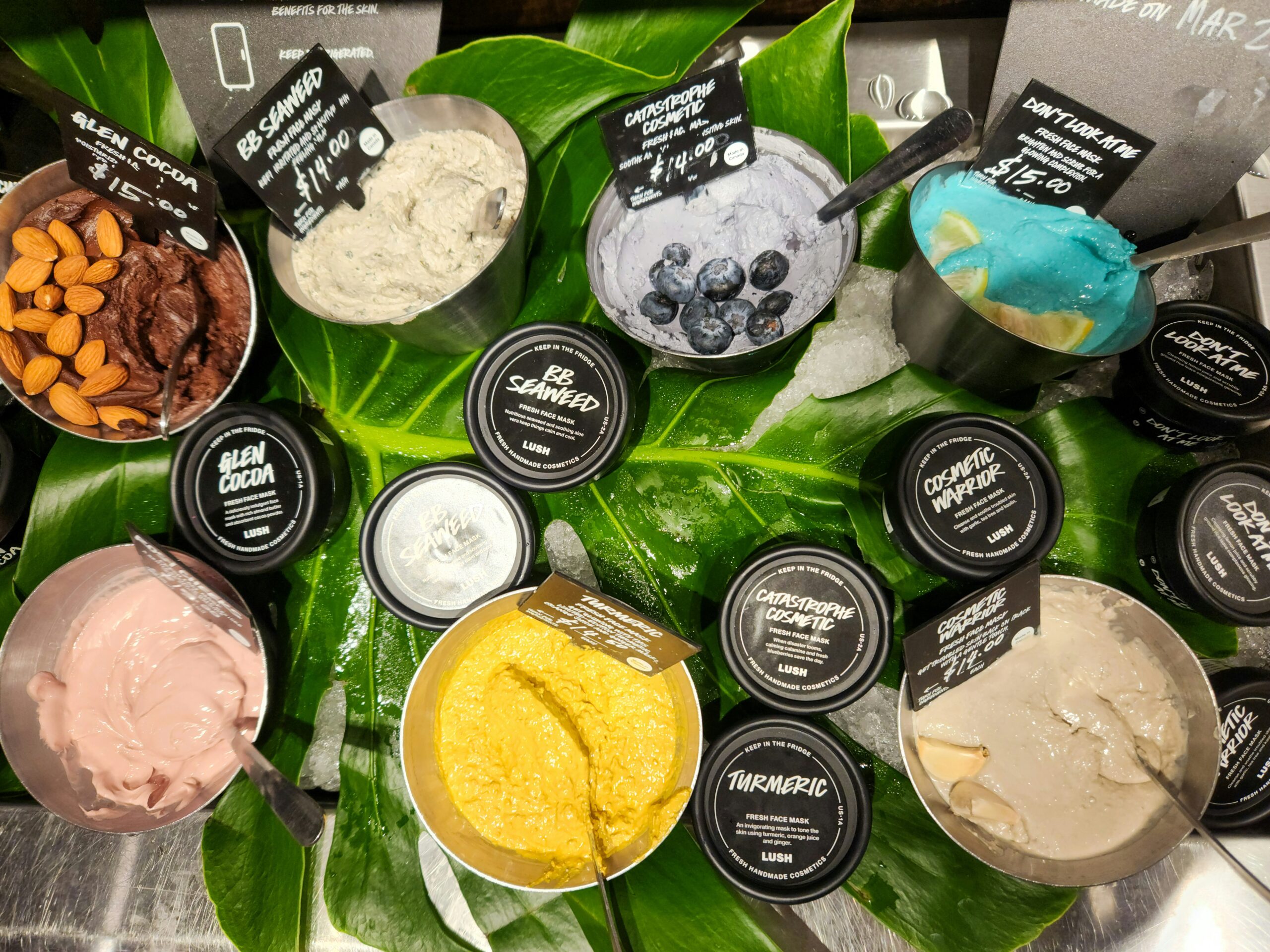 A bottle of organic skincare serum surrounded by leaves