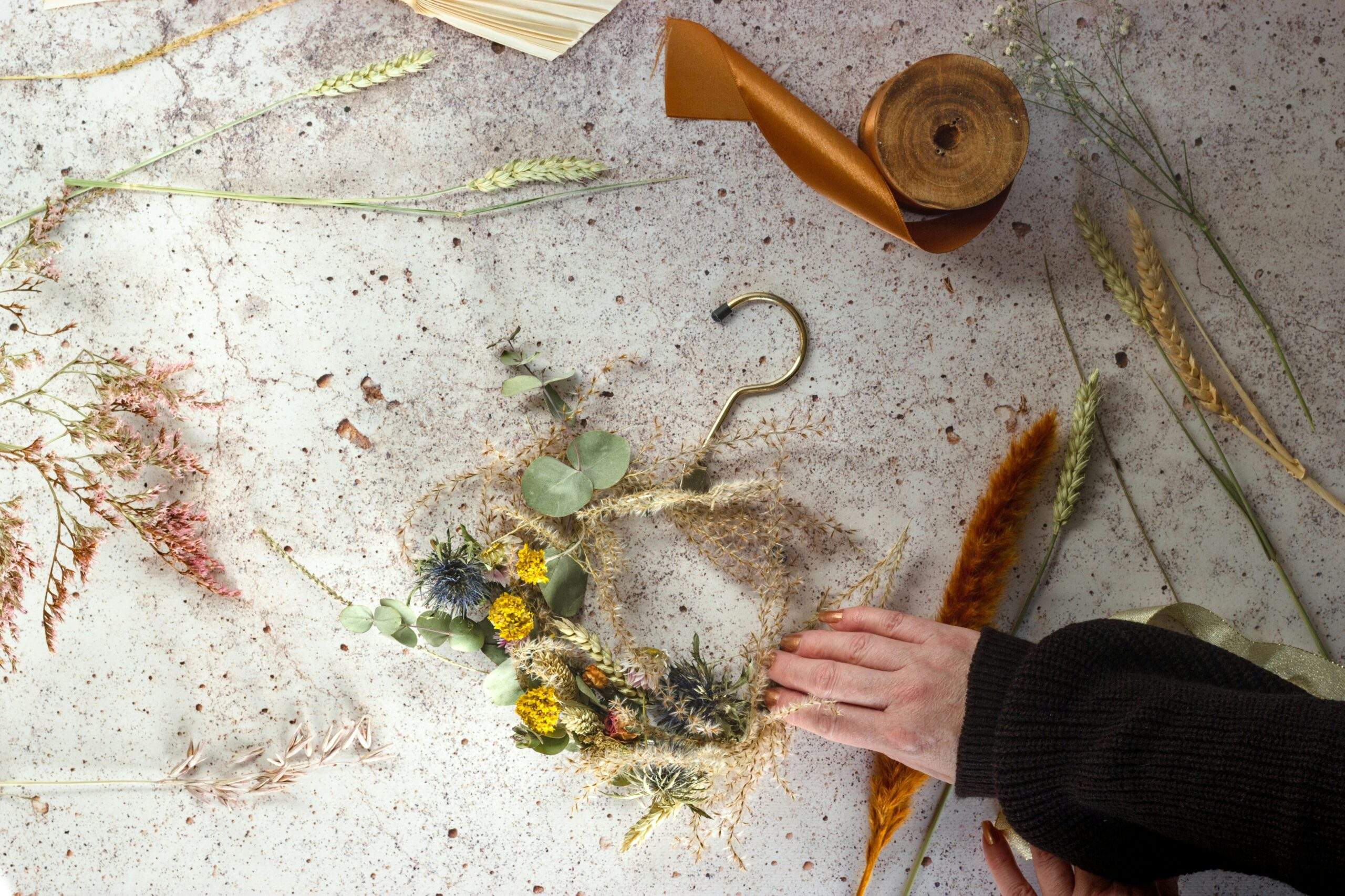 A hands-on photo demonstrating someone creating homemade skincare with herbs