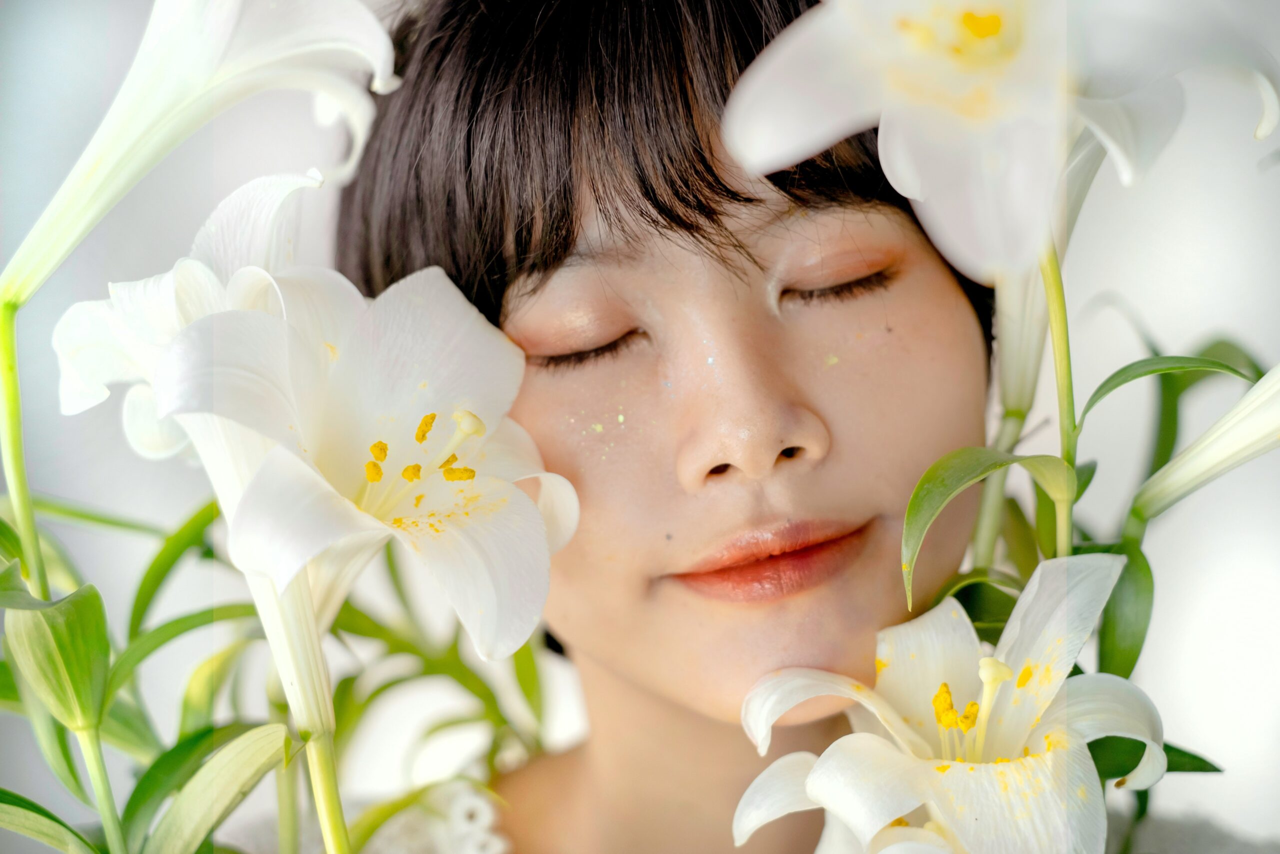 A person applying fresh aloe vera gel from a leaf onto their face.